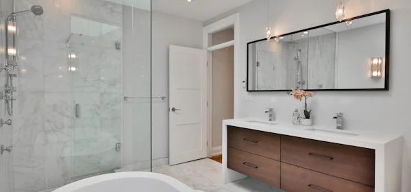 Witte badkamer met glazen douchewand en wastafel